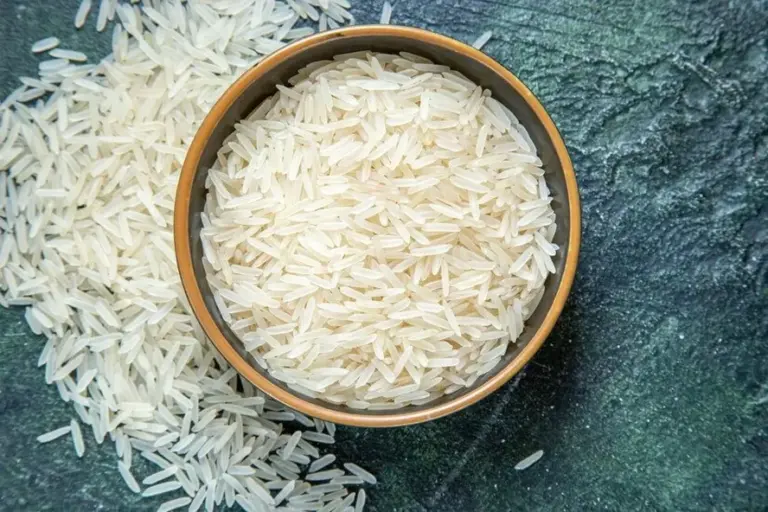 a imagem mostra um pote marrom de arroz branco cru em cima da mesa